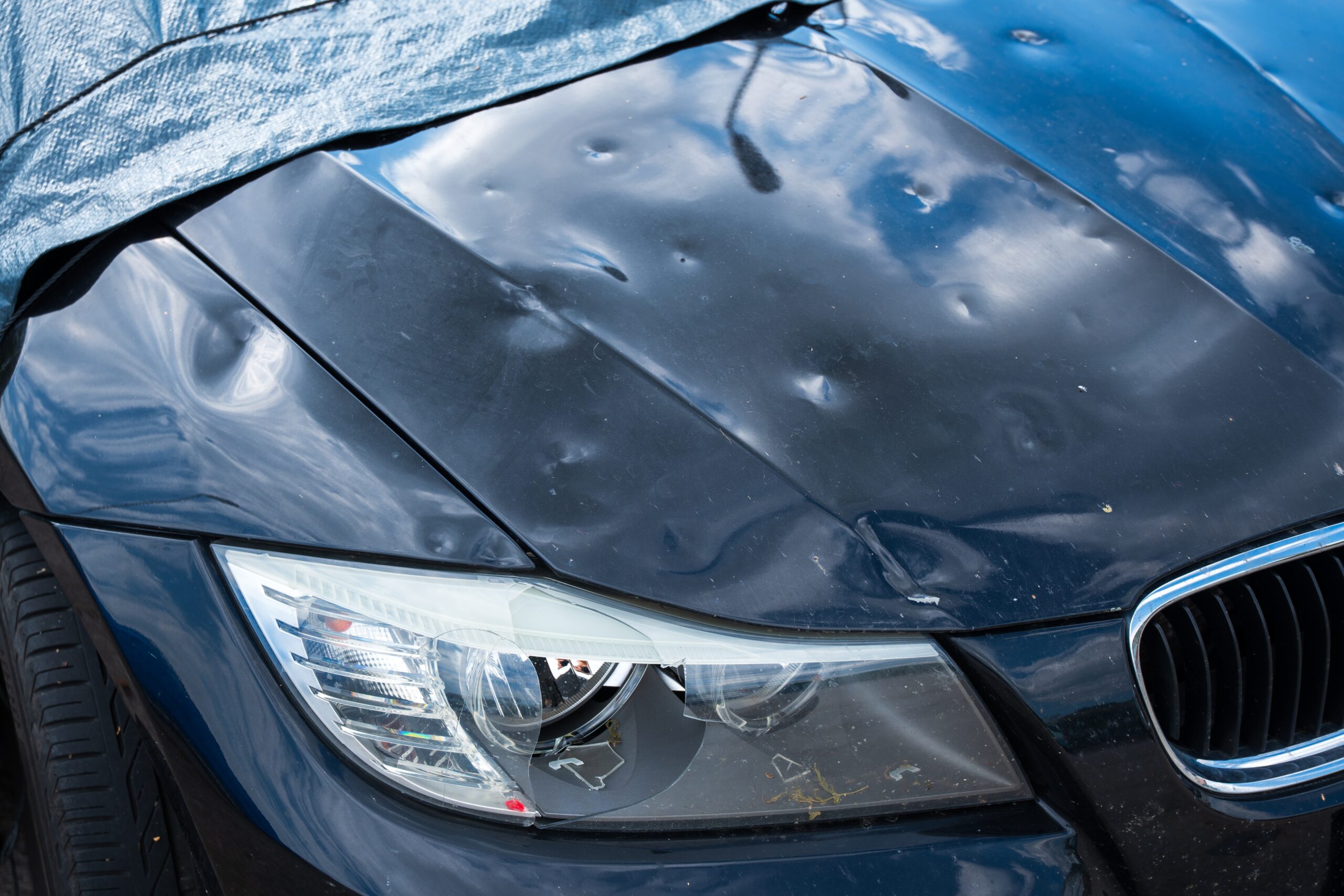 Hail Damage On The Car With Damaged Bonnet And Headlight